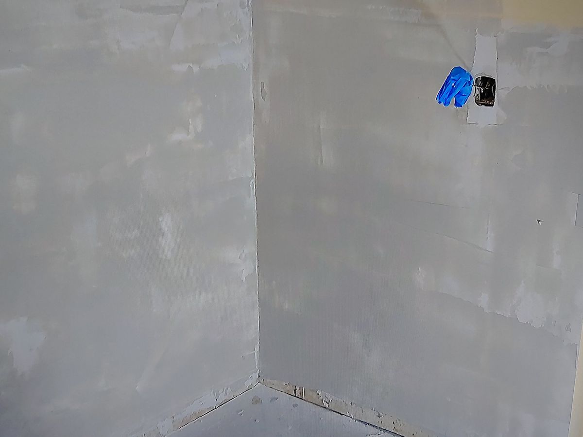 Room corner with walls skim-coated and sanded, ready for paint